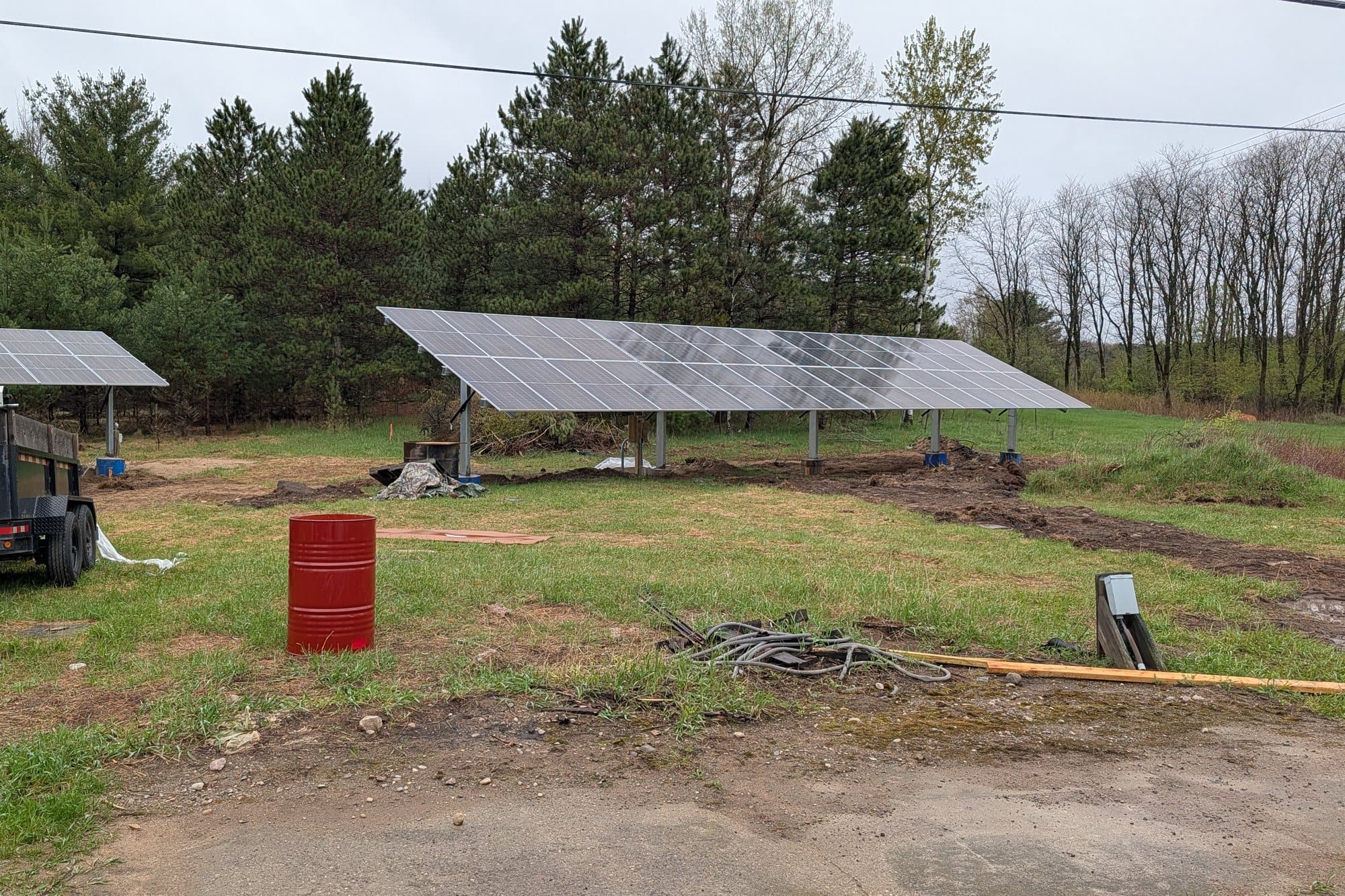 A ground-mounted solar array on adjustable-tilt racking in an open field.